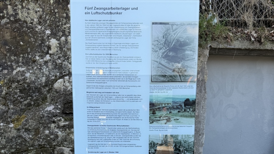 An die Stele eines Hinweisschildes ist nun eine Gedenktafel in Erinnerung an die in den Lagern am Saarbrücker Schanzenberg untergebrachten Zwangsarbeiter:innen. Foto: LHS Saarbrücken